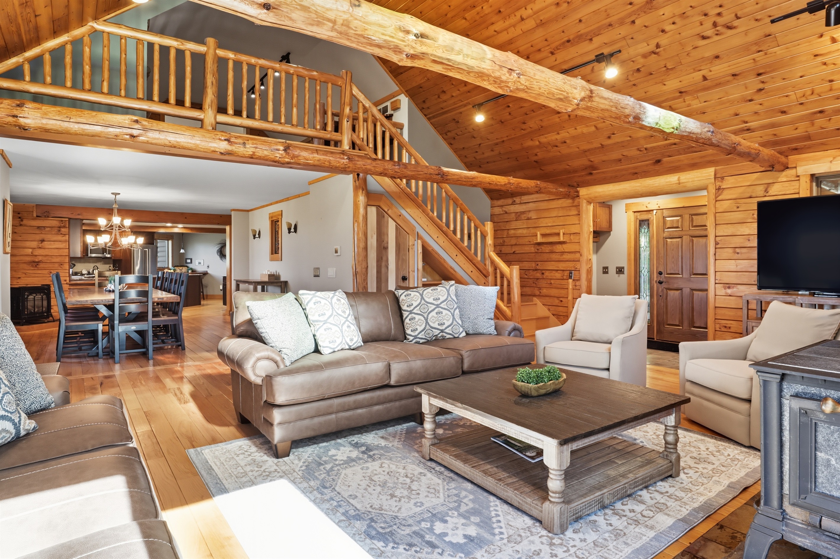 Lofted living room featuring log cabin charm and open layout.