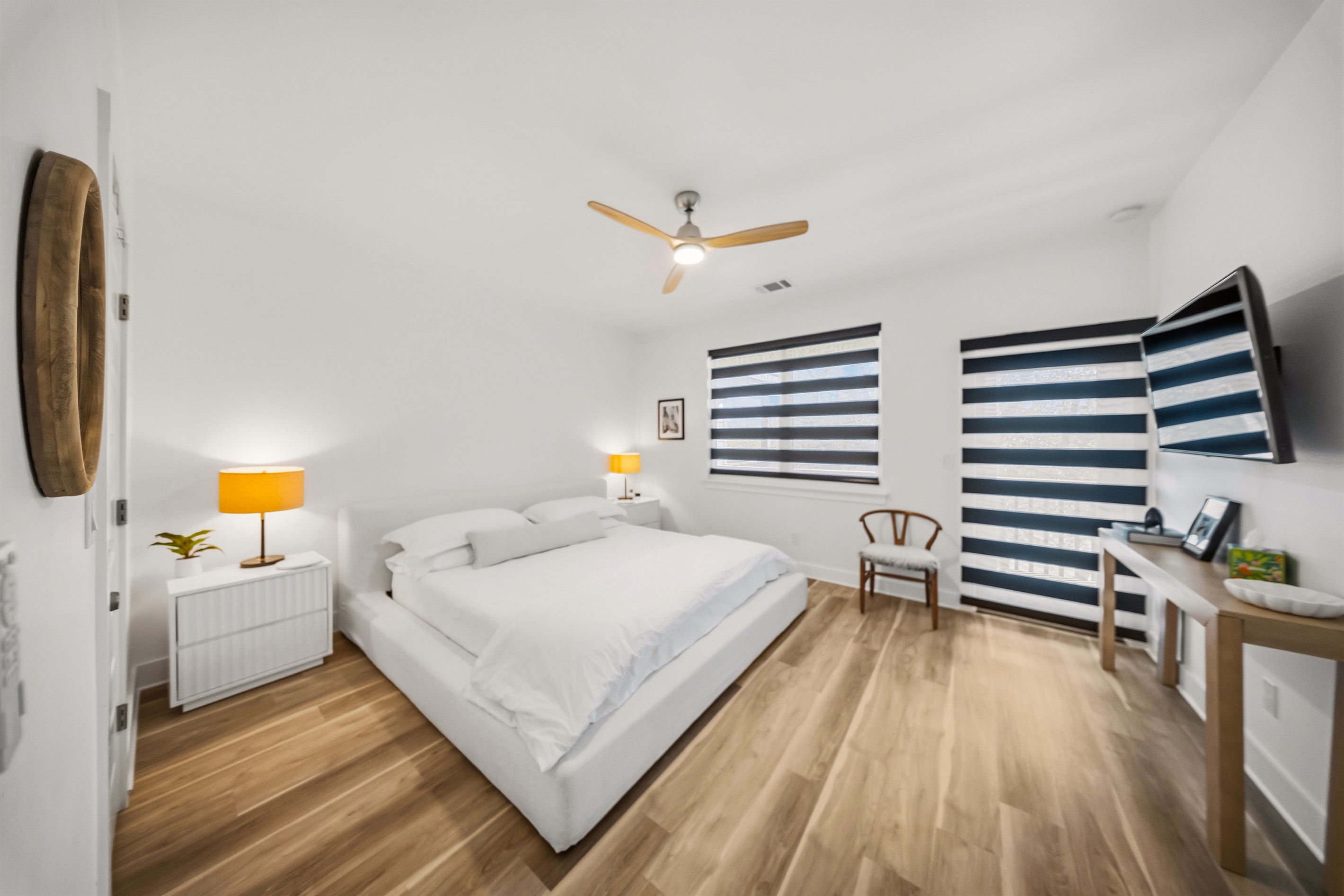 Relax in the spacious king-sized bed with a purple Restore Hybrid mattress designed for cloud-like comfort and deep, restful sleep. The room is surrounded by sleek, minimalist decor and has a private balcony.