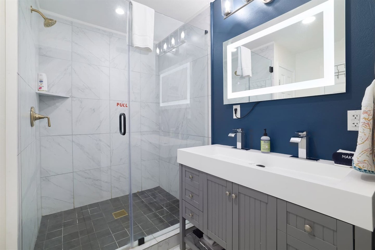 Refresh and recharge in a spa-like bathroom featuring a spacious walk-in shower, sleek finishes, and calming modern design. Clean, bright, and thoughtfully styled for a comfortable stay.