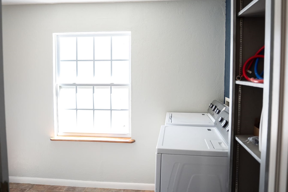 Laundry room equipped with full-size washer and dryer.