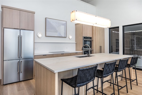 This sleek, modern kitchen is fully equipped with high-end appliances and spacious countertops for preparing group meals with ease. 