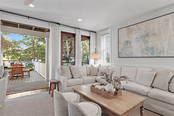 A plush sectional sofa and accent chairs provide plenty of seating for movie nights or afternoon lounging, while large windows fill the room with warm Gulf sunshine.