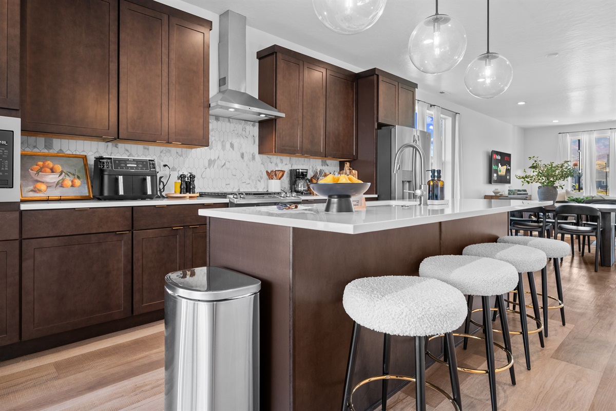 Modern cabinetry, quartz countertops, and designer lighting make this kitchen as beautiful as it is practical.