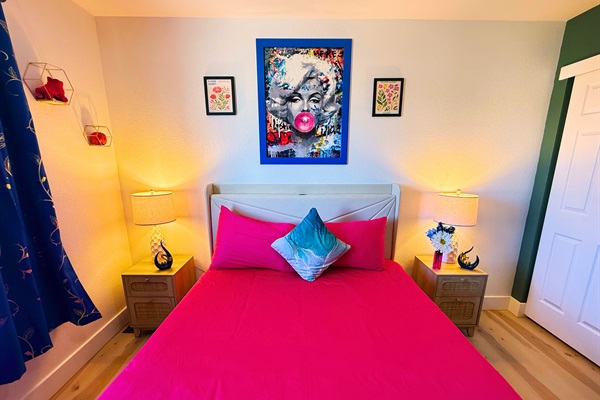 Drift into a restful night in this vibrant and artfully designed bedroom. Soft lighting, cozy bedding, and bold decor create the perfect space to relax and recharge.