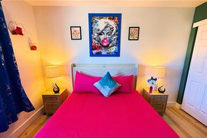 Drift into a restful night in this vibrant and artfully designed bedroom. Soft lighting, cozy bedding, and bold decor create the perfect space to relax and recharge.