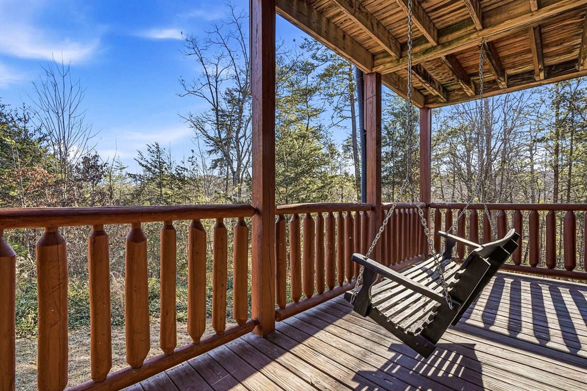 Enjoy breathtaking Smoky Mountain views from your private cabin porch swing near Pigeon Forge, TN | Cozy covered deck seating perfect for stargazing, coffee mornings & unforgettable Tennessee sunsets | Your Pigeon Forge & Sevierville mountain escape awaits