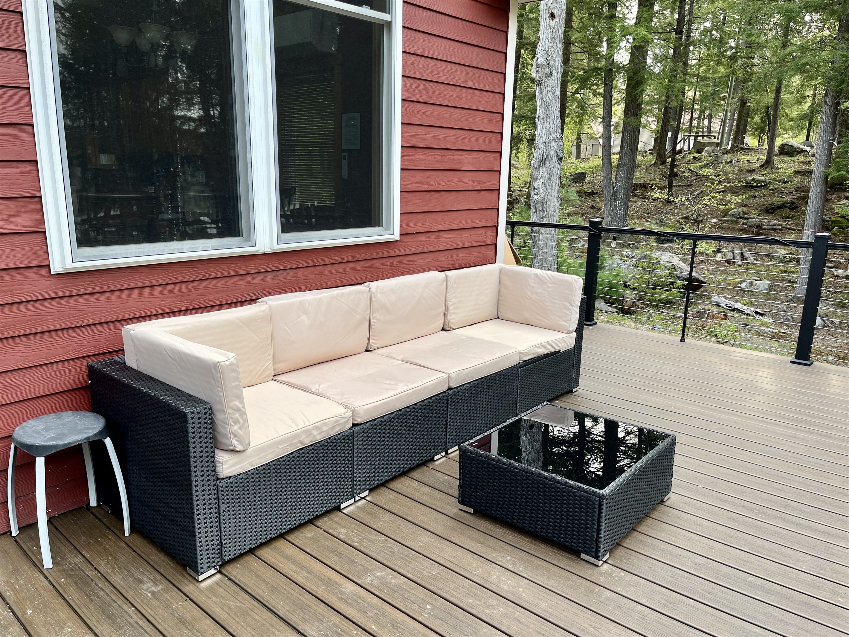 Deck overlooking the lake with outdoor furniture, umbrella, and solo stove.