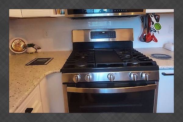 This double oven gas stove is a dream. The center top is a griddle for cooking big batches, and it features air fryer, convection, and standard bake modes. It self-cleans with steam and offers both a small top oven and a spacious bottom one.