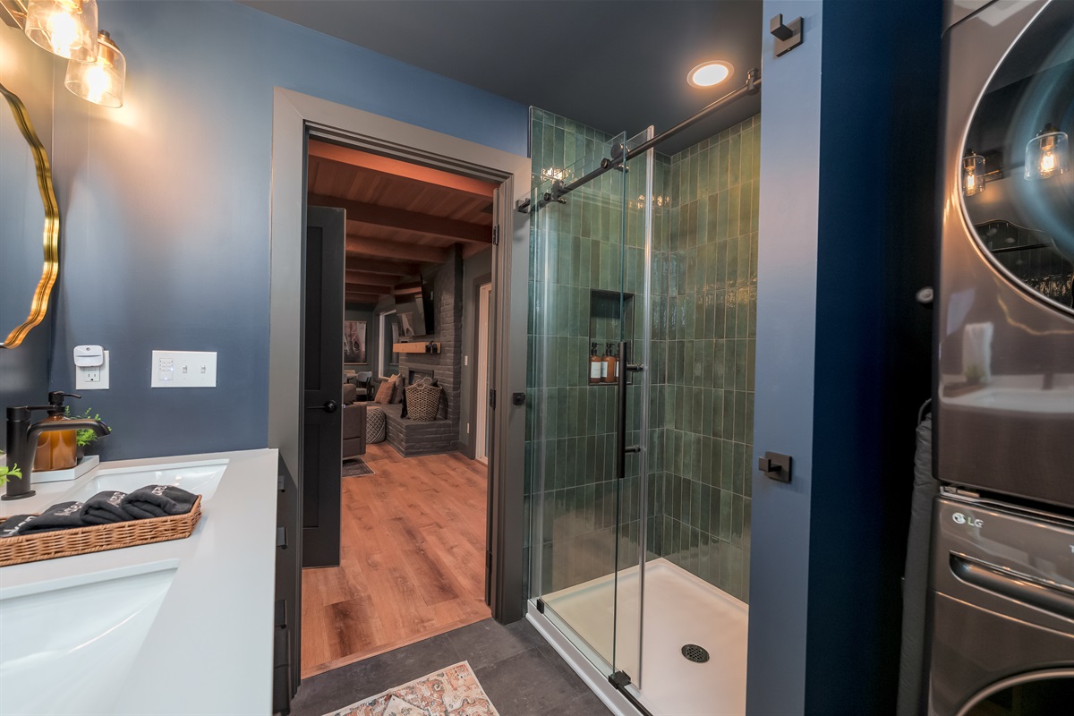 A stylish lower-level bathroom with a walk-in shower, double vanity, and a full-size washer and dryer—perfect for freshening up after days on the mountain.