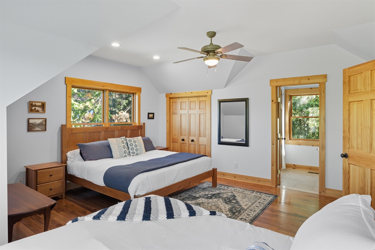 Inviting bedroom with plush bedding and wood accents.