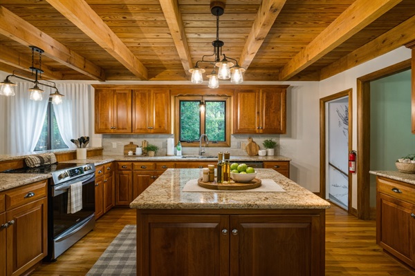 Full granite island, stainless range, timber ceiling beams, and enough counter space that two people can cook at the same time without getting in each other's way.