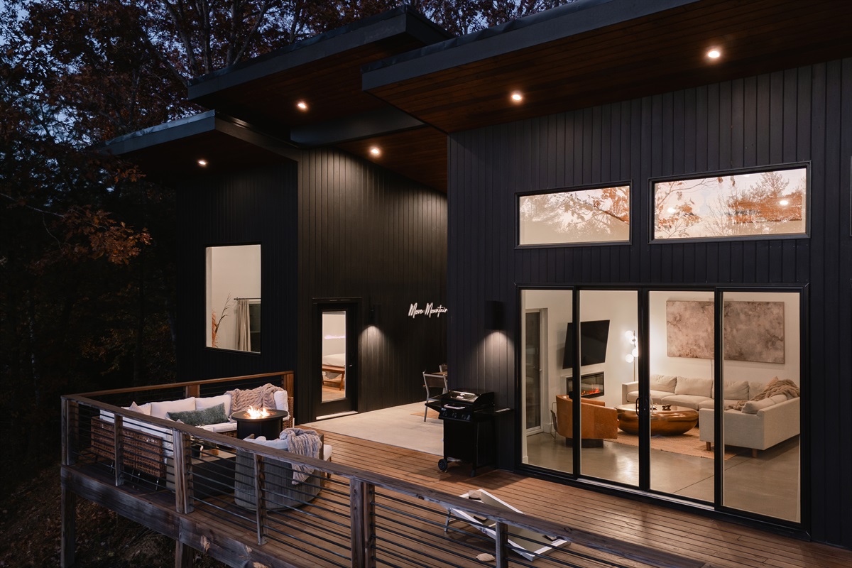 {Outdoor Lounge} The Glass House invites you to linger outside—cozy blankets, cornhole, giant Connect 4, and the forest glowing as twilight settles in. A mountain moment you won’t forget.