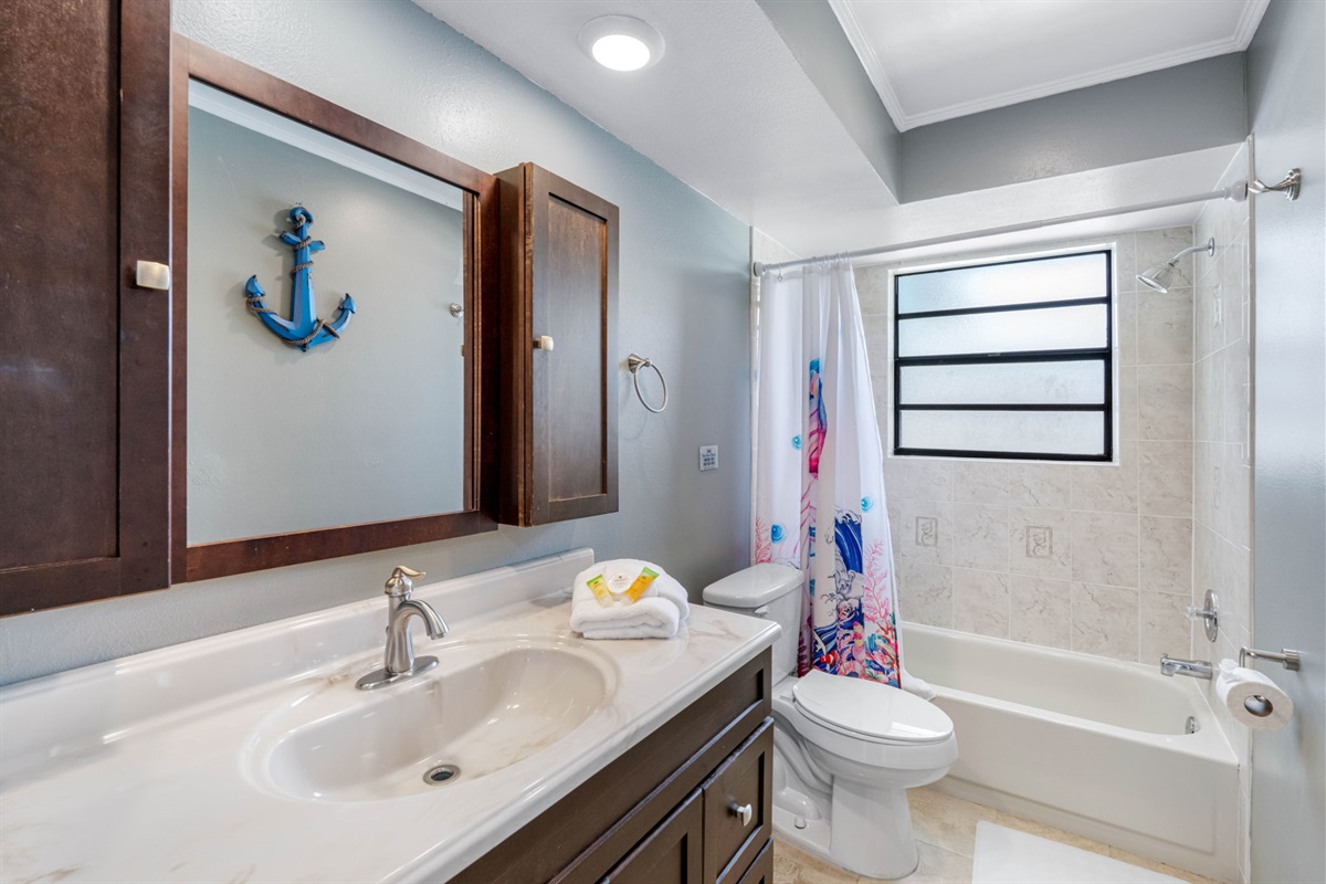Soft, overhead lighting complements the natural light streaming in from the frosted privacy window, creating a bright yet soothing environment throughout the day.