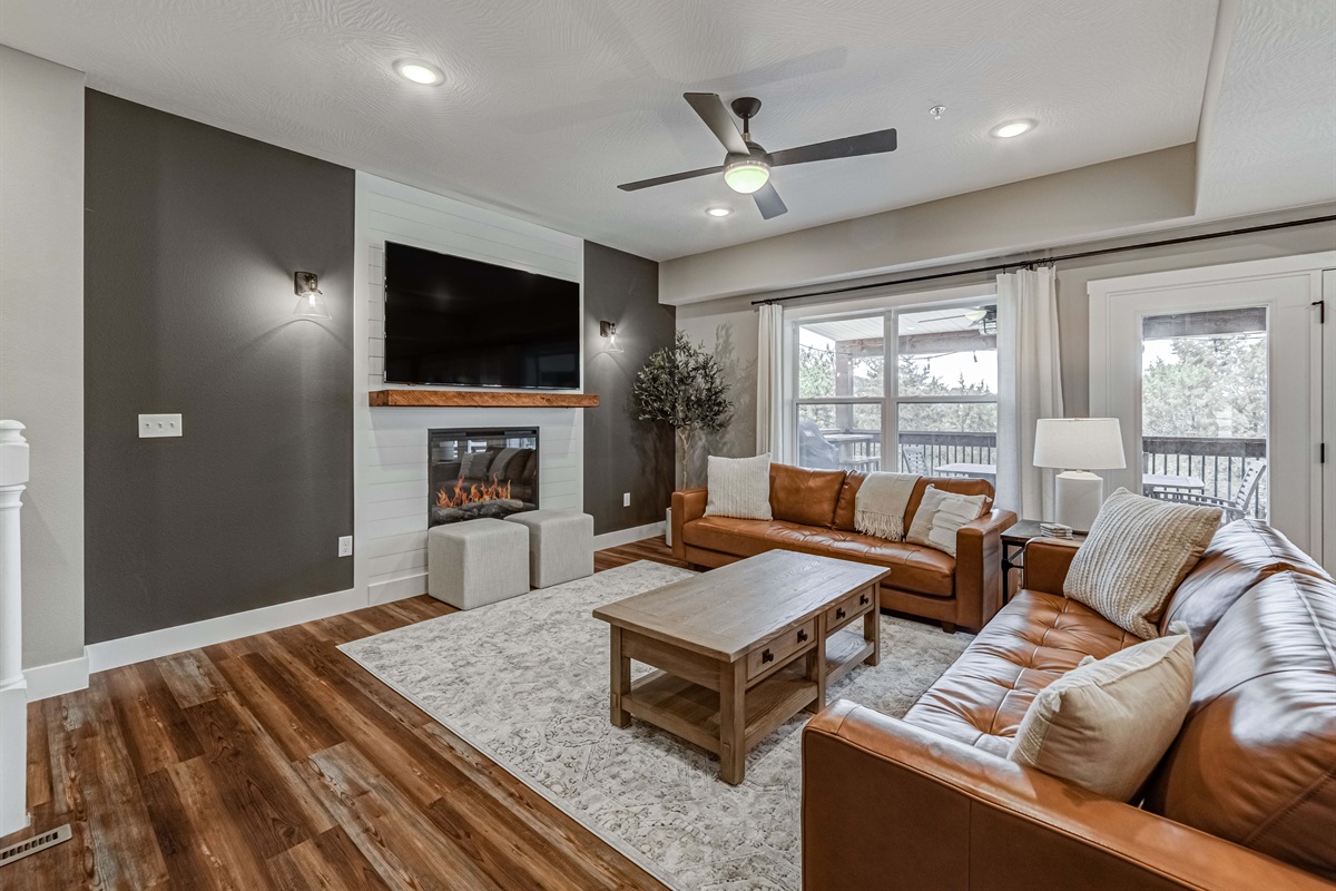 Main level living space with electric fireplace and large TV