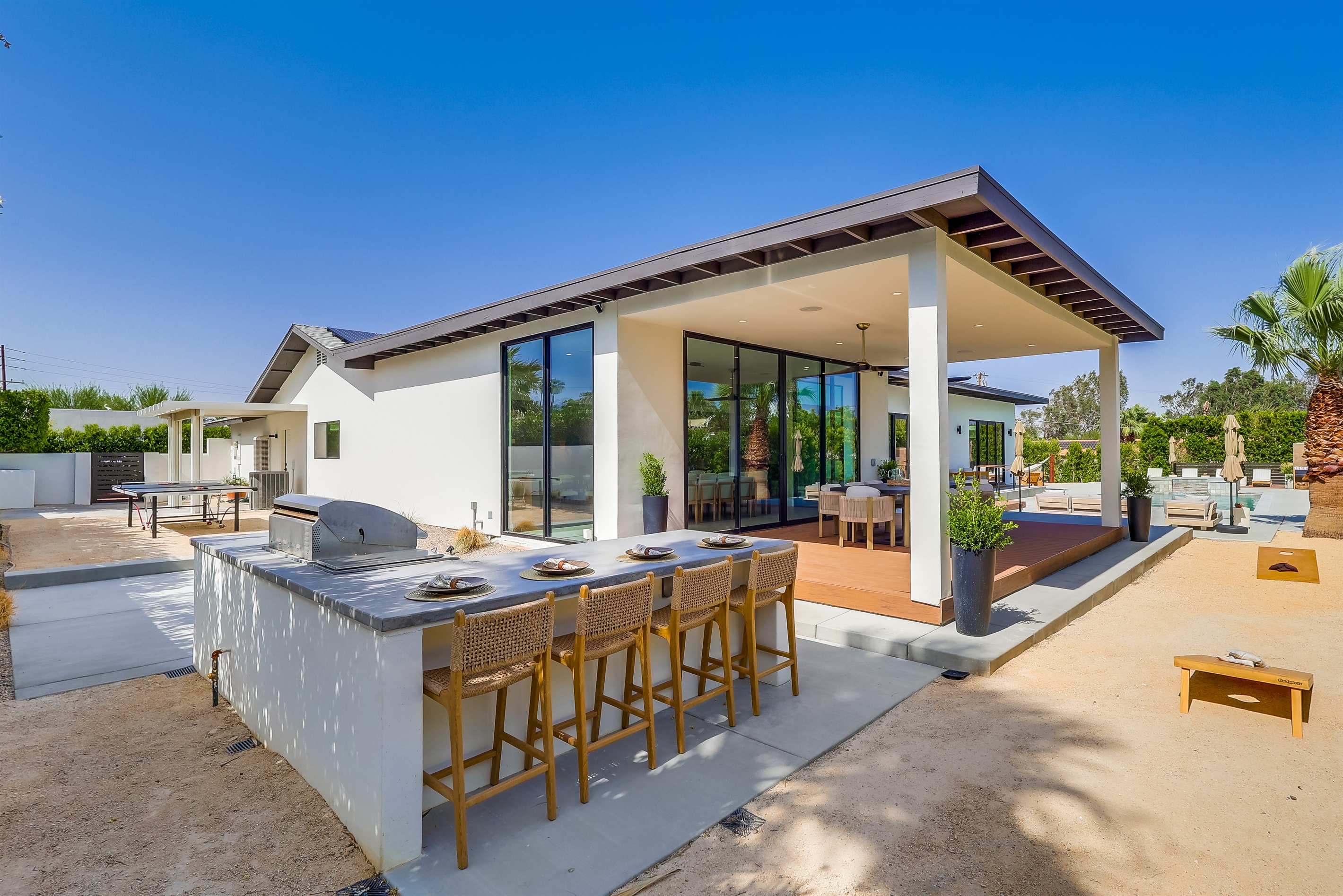 Outdoor dining and activities including corn-hole and ping pong
