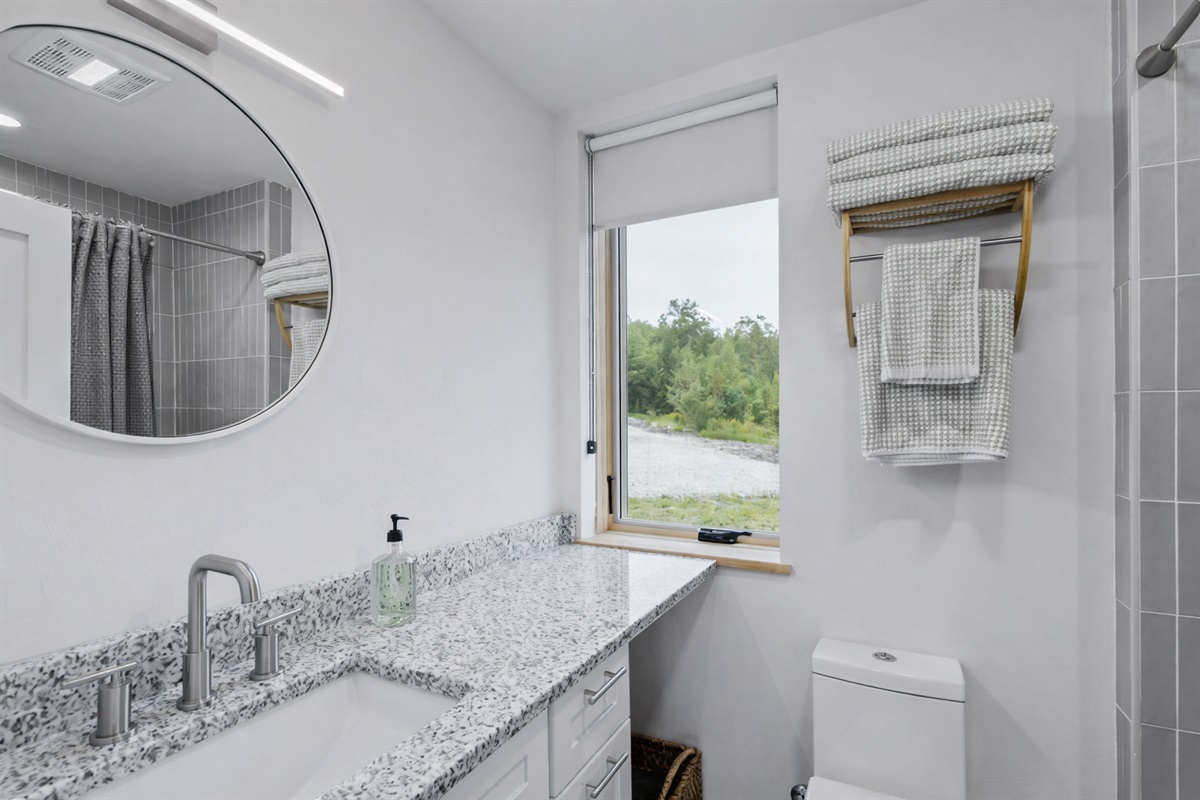 The first floor full bathroom features a modern tiled shower/bath combo.