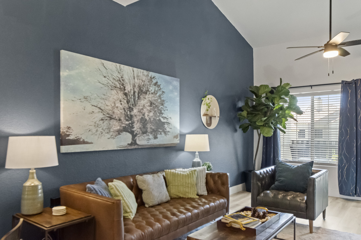 Relax in the stylish living room featuring a comfortable sofa, accent chairs, large TV, and plenty of natural light.