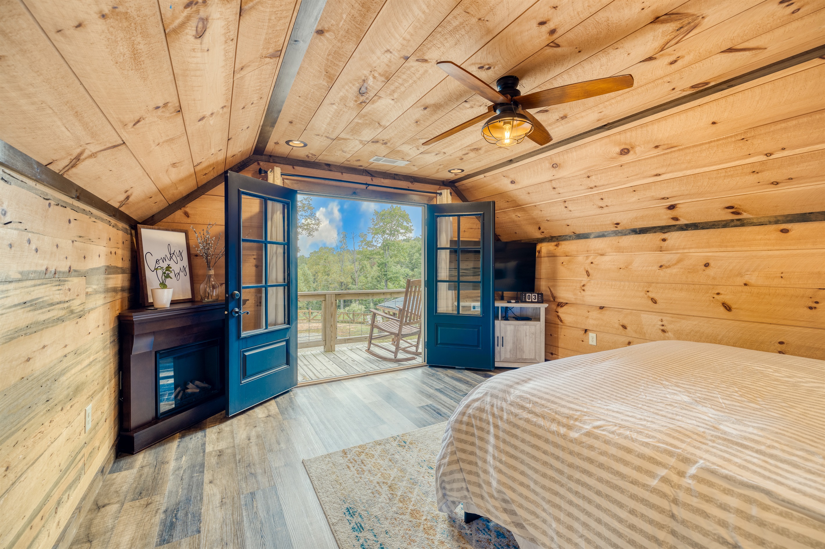 King bedroom with smart TV, gas fireplace and balcony.