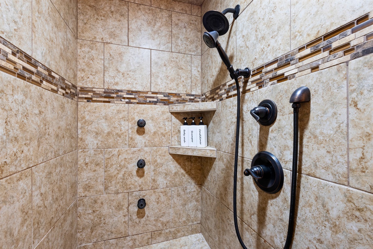 Spacious tiled shower with built-in seating—relax and recharge.