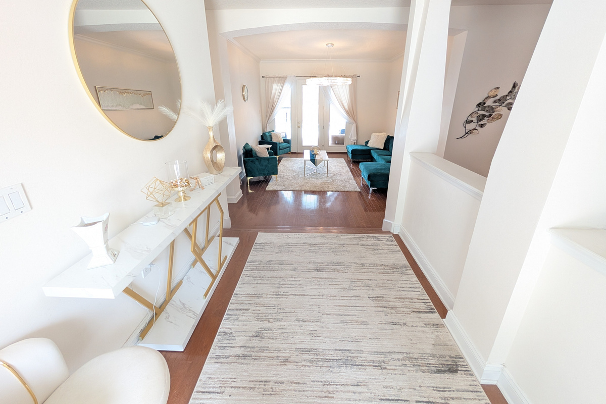 A welcoming entryway opens into multiple spacious living and gathering areas throughout the home.