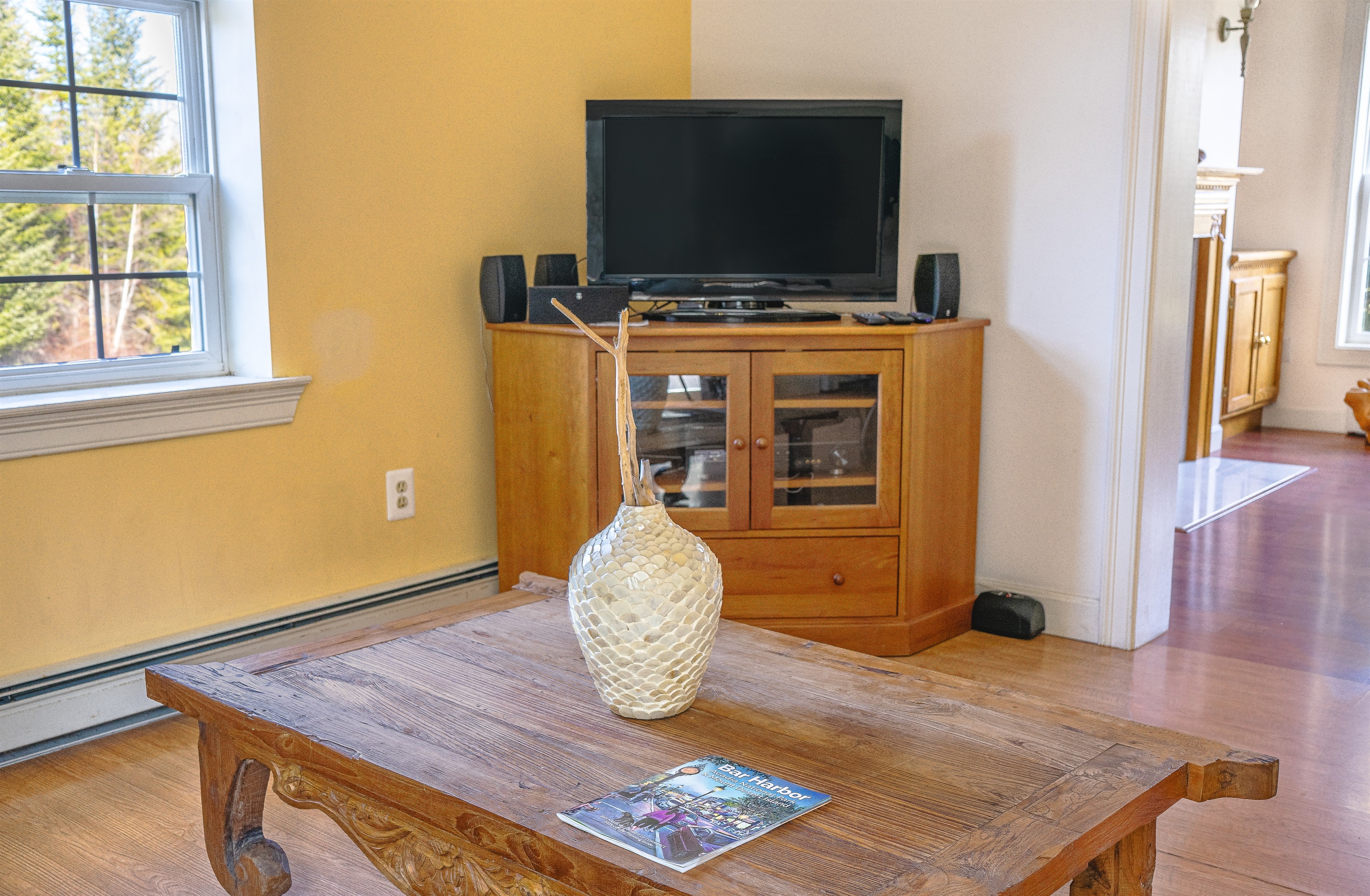 Coming back inside, the living room welcomes you with local charm and modern tech. Enjoy your favorite shows on the Roku Smart TV or relax by the window with a guide to Bar Harbor. Every detail is curated for a premium Southwest Harbor experience.