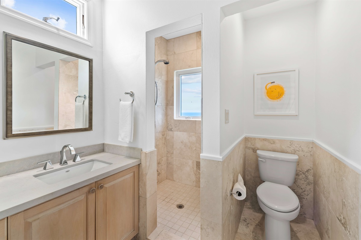 Sleek en-suite with double vanity, hair dryer, walk-in shower  and soft lighting. Functional and elegant.