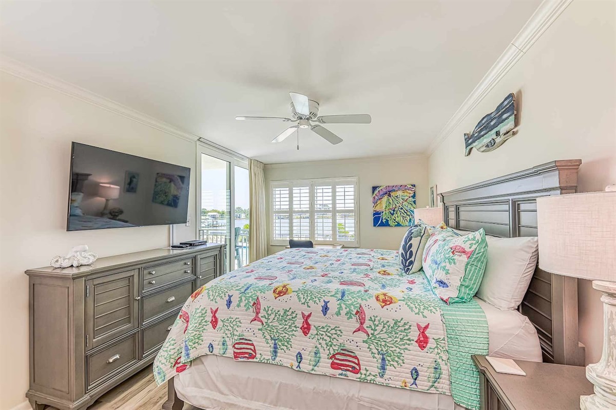 Main Bedroom: Wake up to vibrant decor and serene waterfront views—your beach retreat awaits!