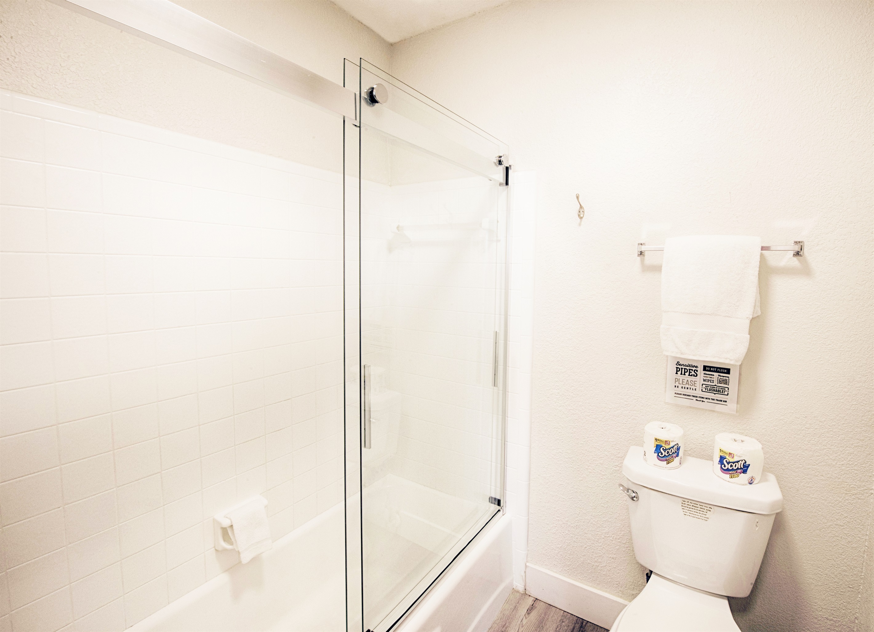 Private shower and tub with glass doors.