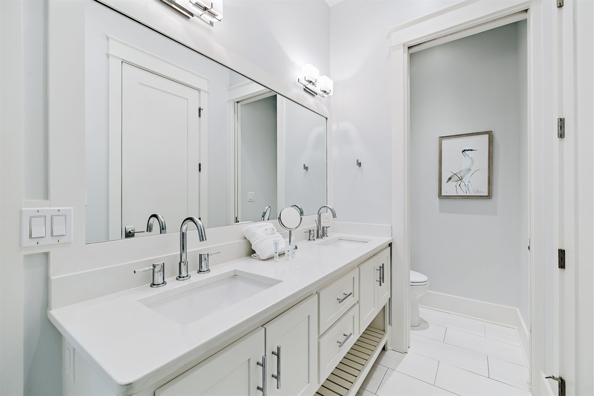 First-floor master ensuite bathroom featuring double vanities, a spacious walk-in closet, and a beautiful walk-in shower.