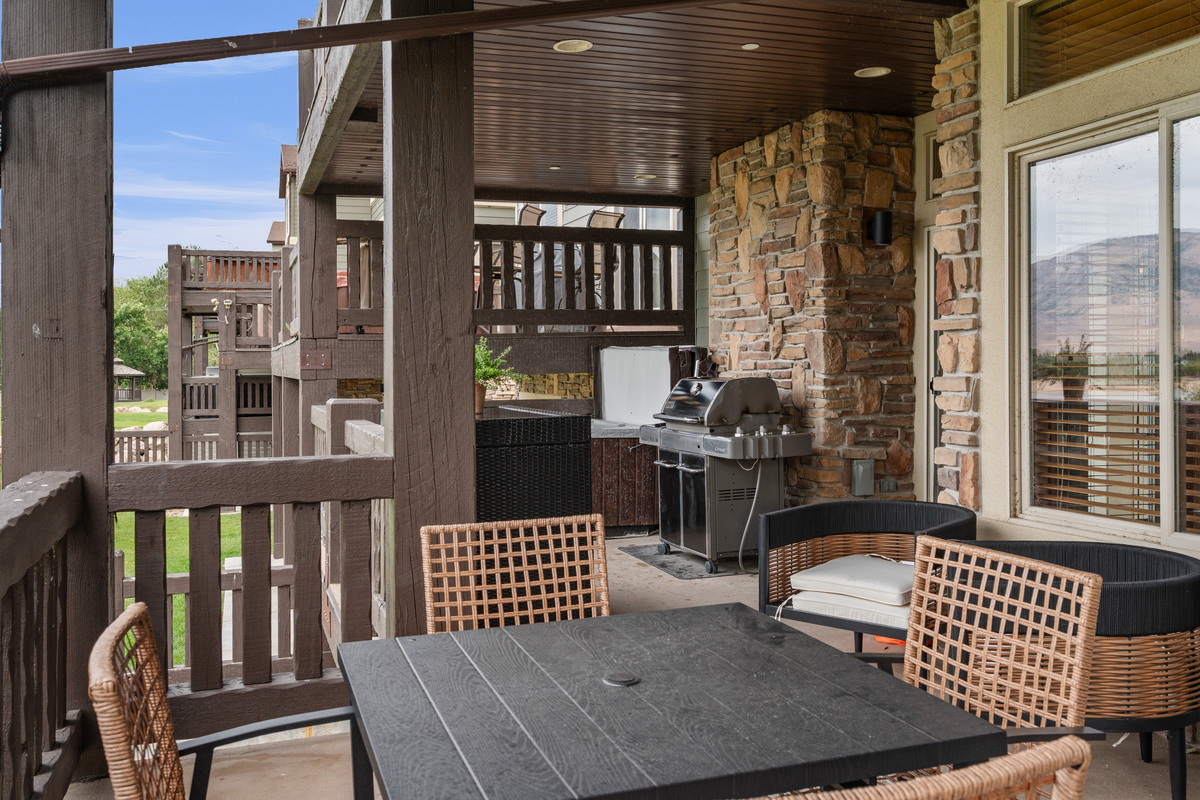 Covered balcony features outdoor dining, comfortable seating, a BBQ grill, and your own private hot tub.