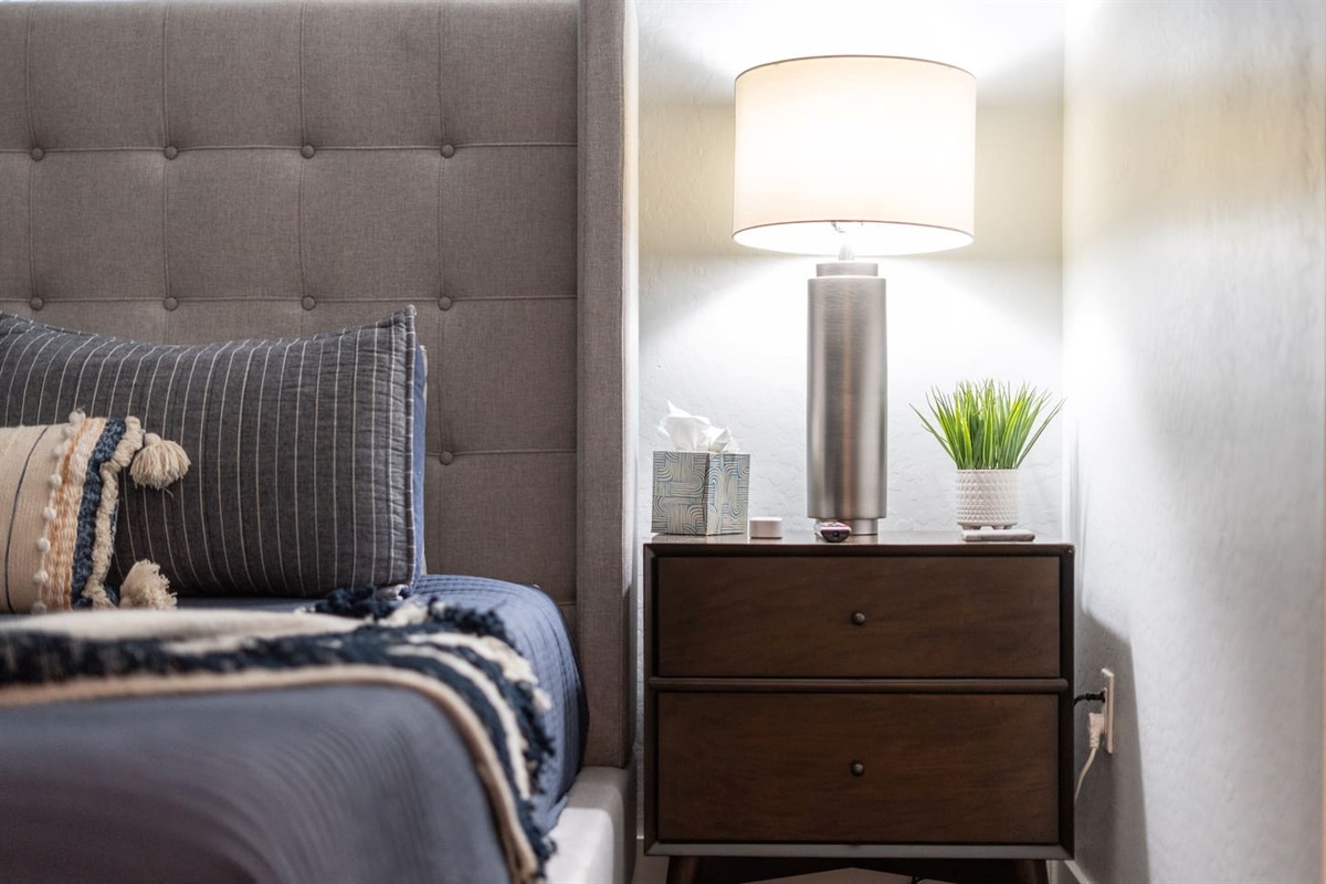 Chic bedside table with a stylish lamp, providing both function and ambiance to your bedroom.