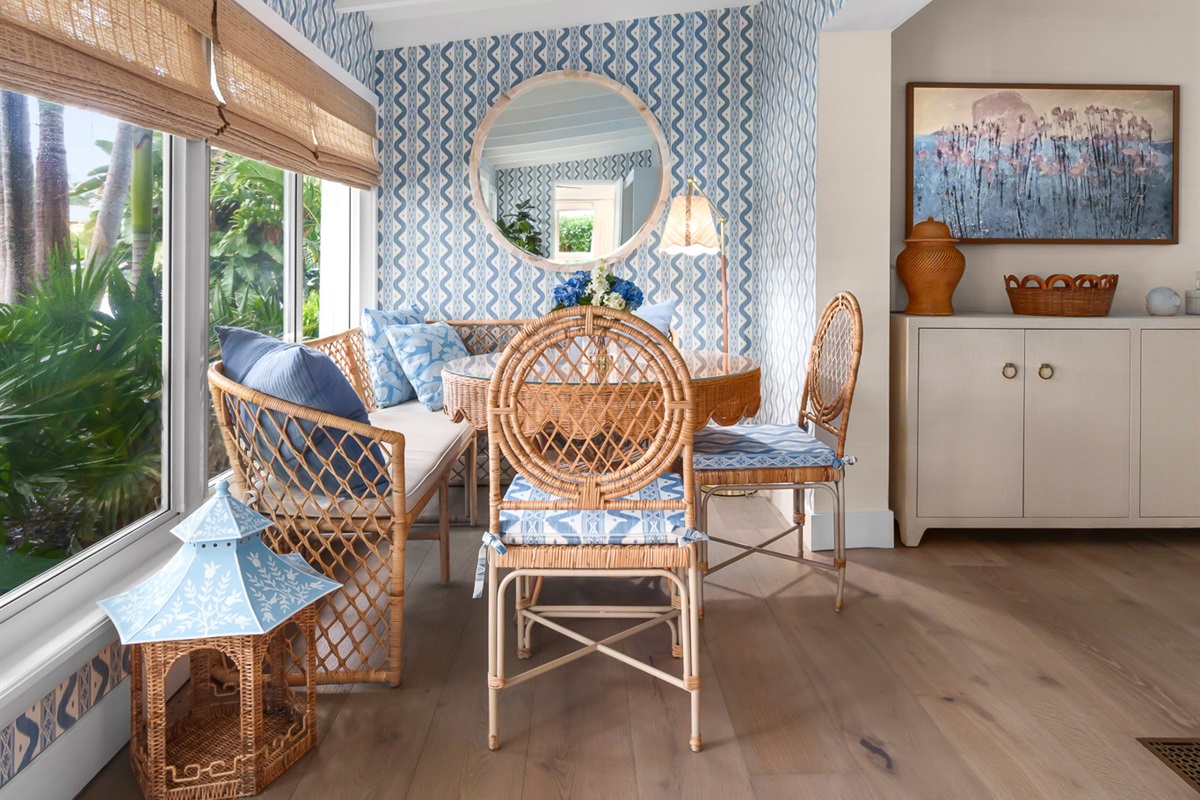 Enjoy a meal with a view. This sun-drenched dining nook features beautiful rattan textures and designer wallpaper.