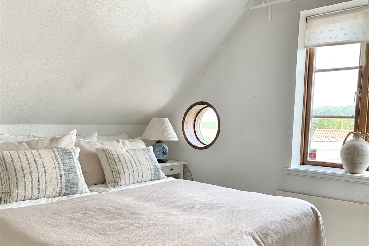 Sovrum med dubbelsäng och garderober en trappa upp. 