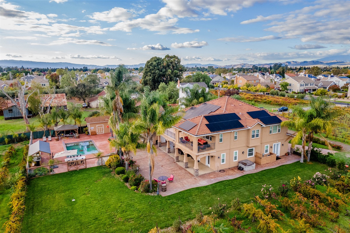 Aerial view of Caldeira Estate with lawn, pool, hot tub, outdoor kitchen, and patio.