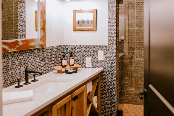 Designer vanity in Cutter's Quarters Bathroom #1 &mdash; modern Western tile, curated Western art, and your own private bath in the flagship suite.