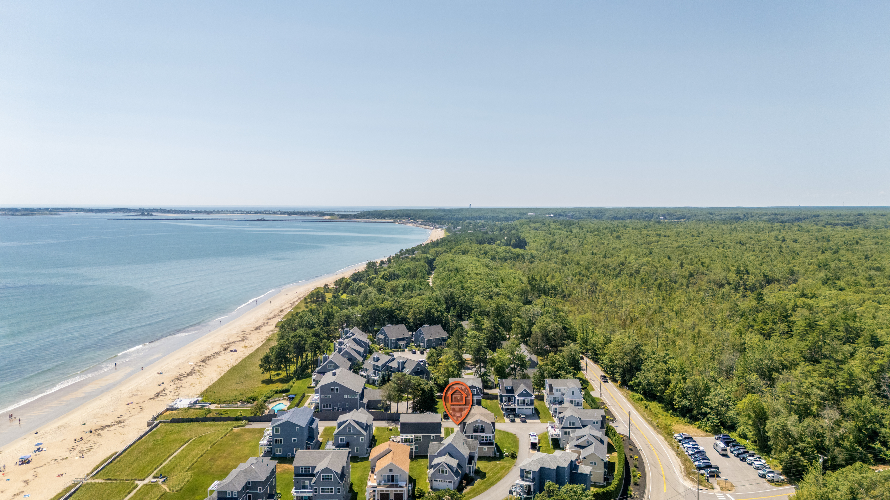 A sweeping aerial view captures the neighborhood tucked between the coastline and surrounding natural landscape.