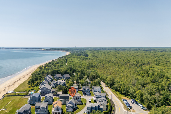 A sweeping aerial view captures the neighborhood tucked between the coastline and surrounding natural landscape.