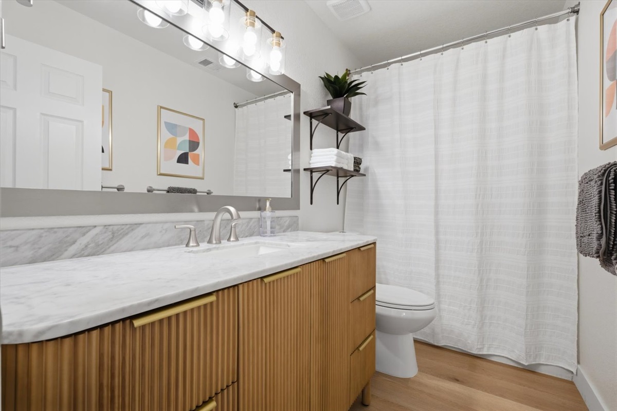 Full upstairs hall bathroom has a shower/tub, and a large vanity with lots of storage. Hair dryer and shower toiletries provided.