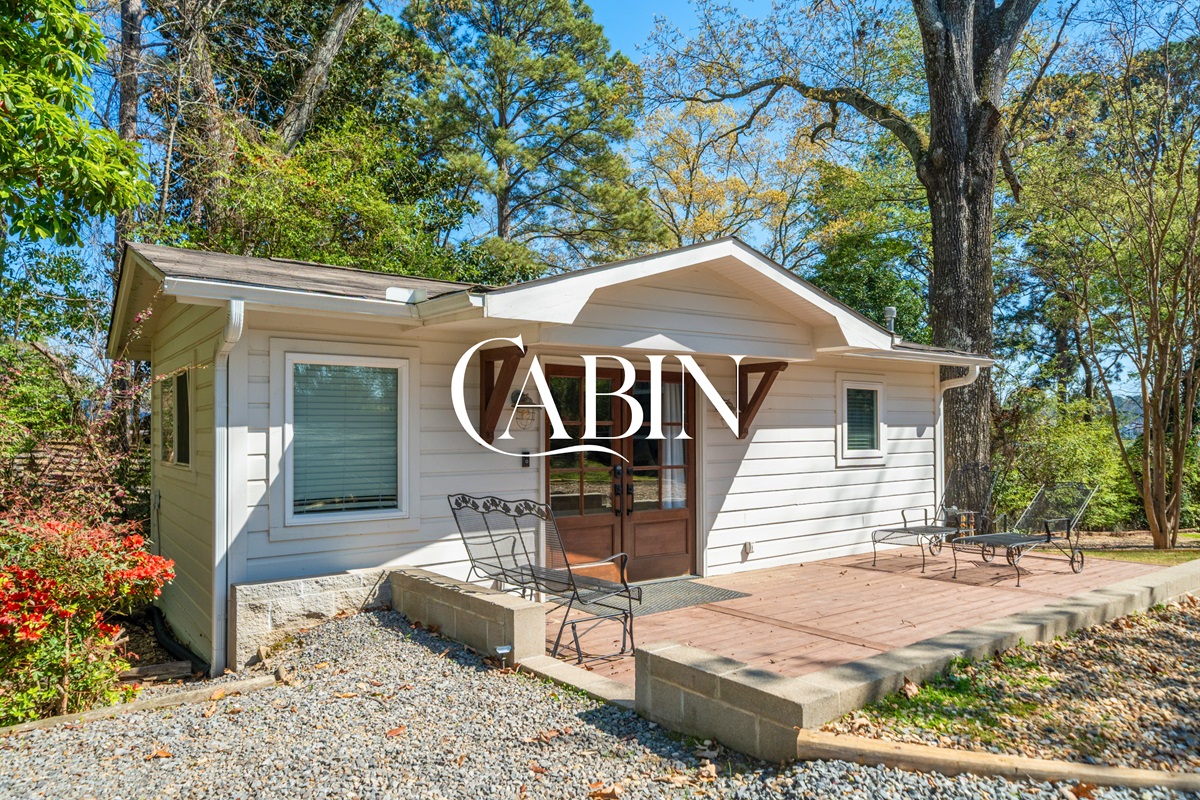 Arrive at the cabin where a charming exterior and wooded surroundings create a peaceful, tucked-away retreat separate from the main home.