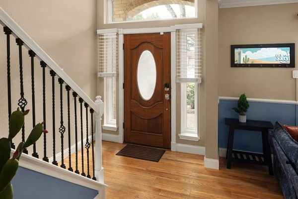 Stylish front entry with warm natural light, elegant staircase, and welcoming design—your perfect first impression upon arrival