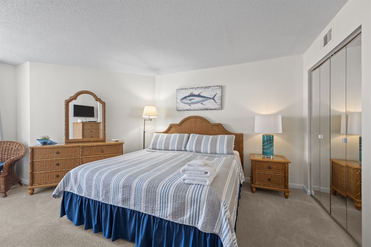 Spacious master bedroom with coastal decor, ensuite access, and a calm atmosphere for restful nights
