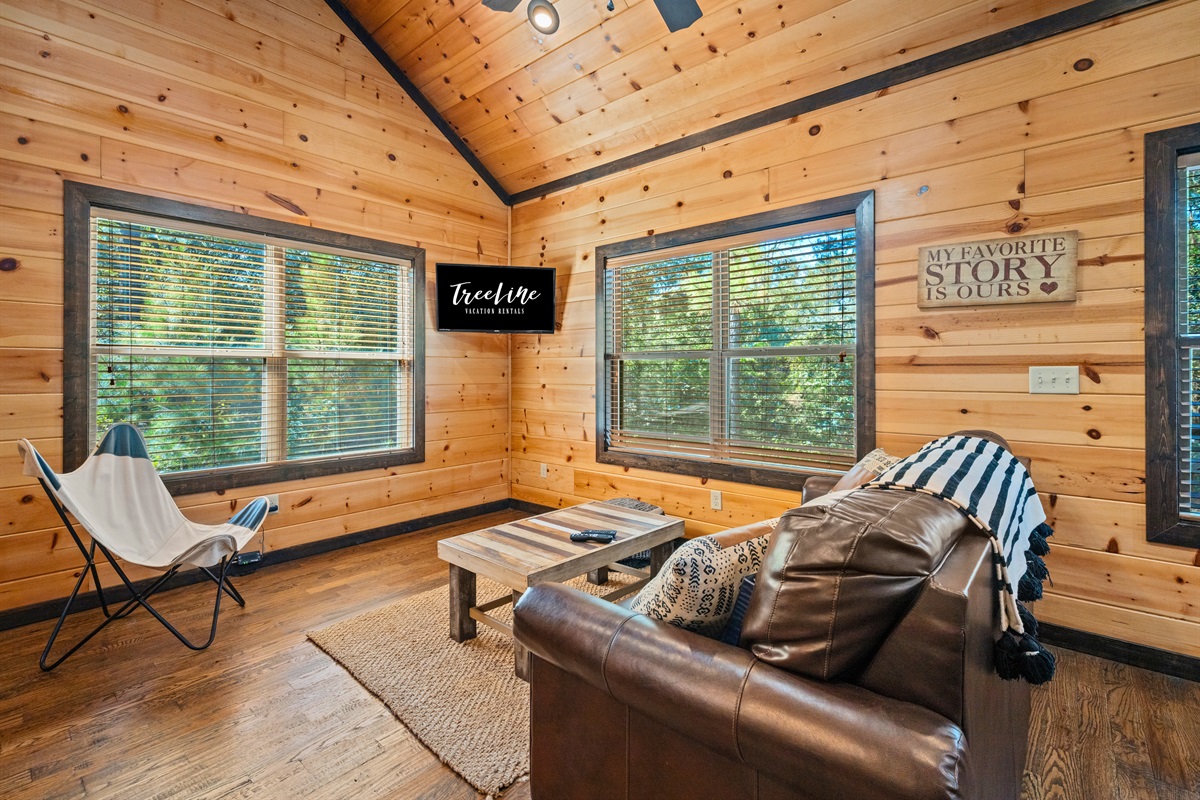 Bright sitting area with forest views and comfortable seating.
