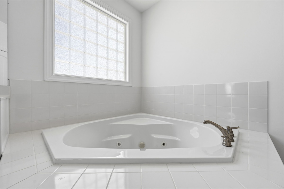 Unwind after the beach in the spacious jacuzzi tub with natural light and a relaxing atmosphere