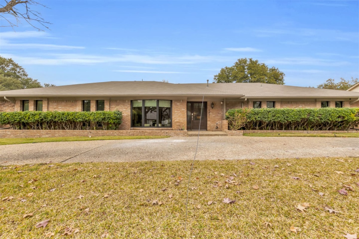 Front entry of a traditional Dallas home featuring a circular driveway, offering easy access, classic curb appeal, and convenient parking upon arrival.