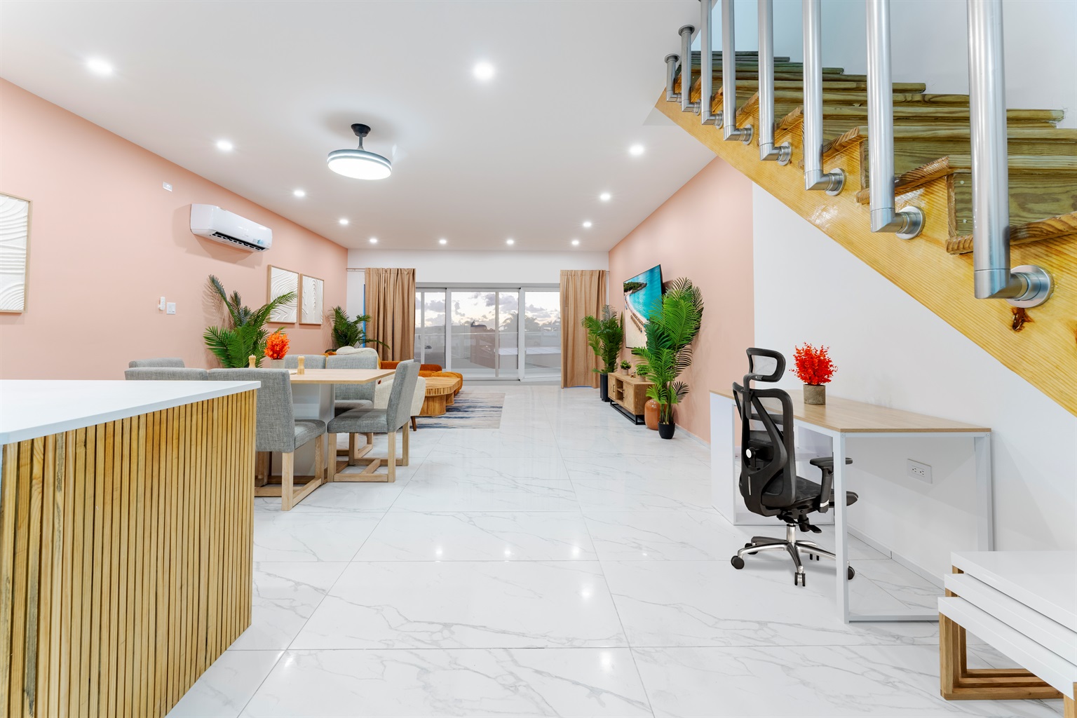 Bright, open living and dining area with modern coastal décor and full wall of sliding doors