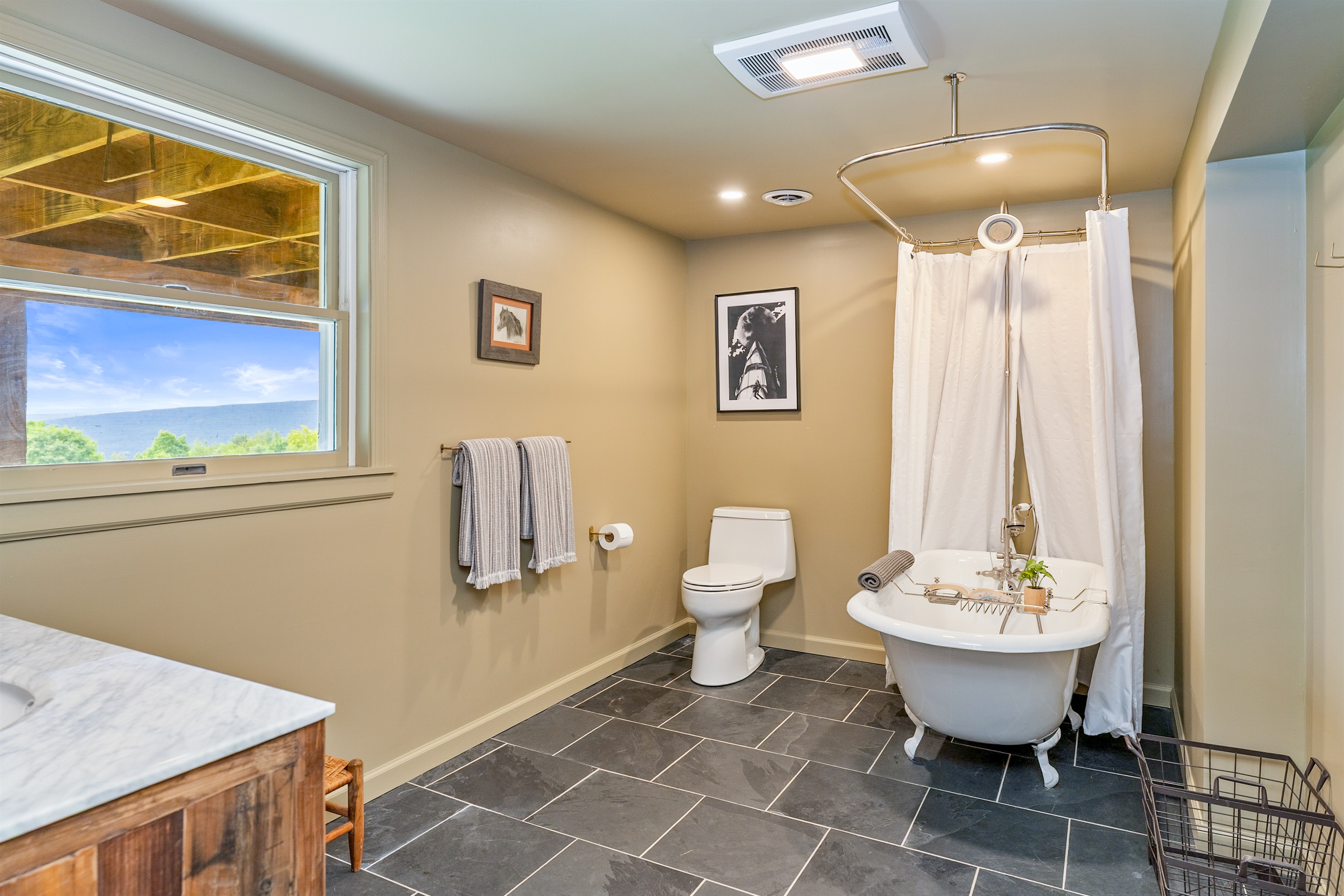 Unwind in this charming clawfoot tub with shower, set in a spacious bathroom on the lower level