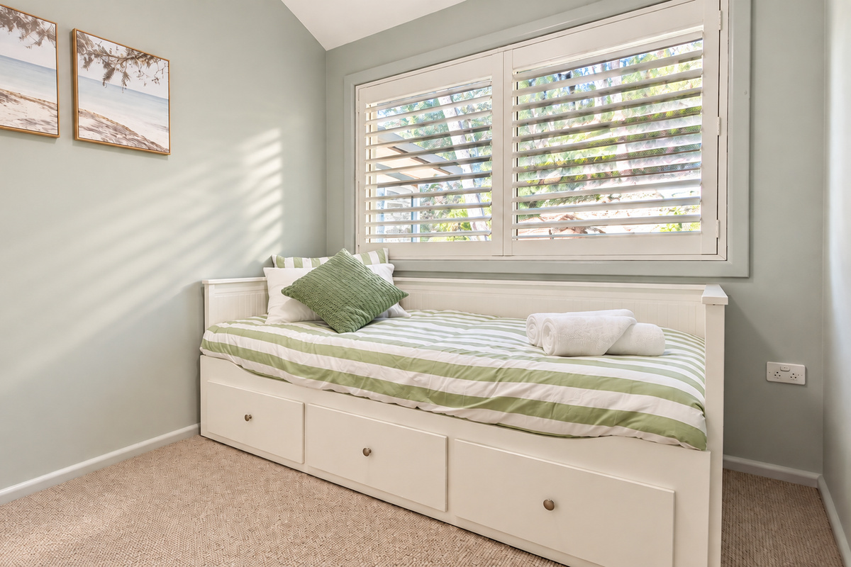 Natural light and calming coastal colours make this charming single bedroom feel bright and inviting.