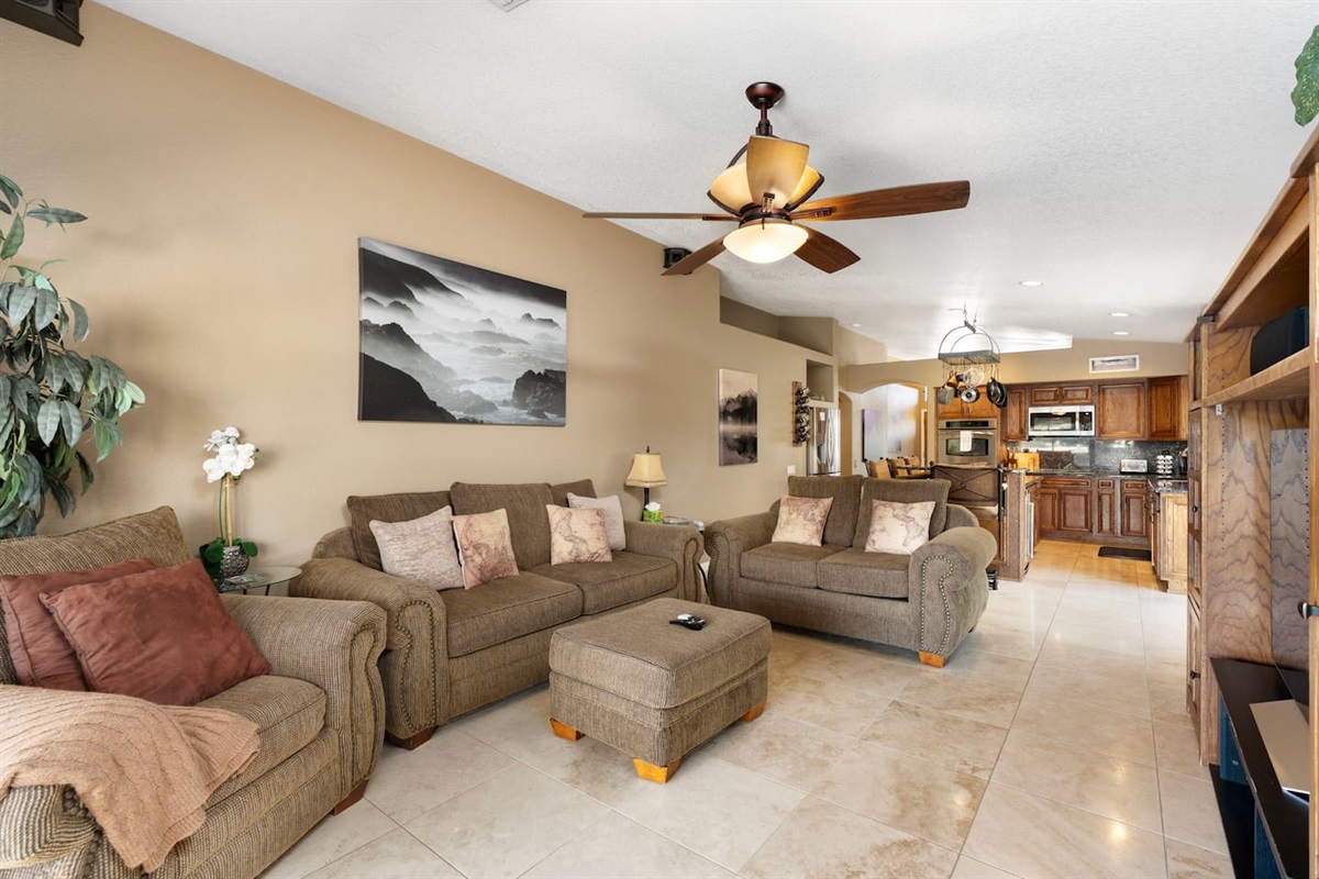 Bright and airy living space with room for the whole group, with vaulted ceilings, ceiling fan, and a clear sightline to the fully equipped kitchen.