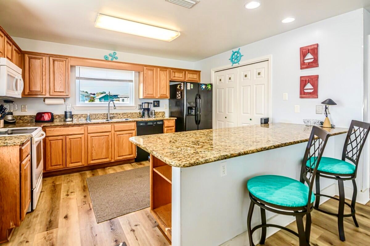 An open kitchen and bar area where everyone can gather while meals are prepared