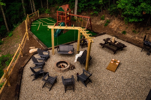 Family Fun Yard with Fire Pit, Swing Seats, Mini-Golf, Playground and Games—Endless Entertainment for All Ages.